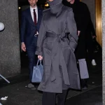 Victoria Beckham draagt een trenchcoat met een hoge kraag.
