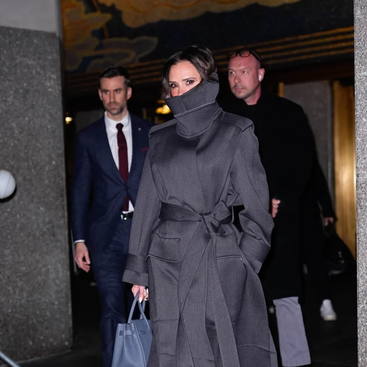 victoria-beckham-verhult-haar-glimlach-zoals-alleen-zij-dat-kan-in-een-stijlvolle-trenchcoat-met-hoge-kraag-376379