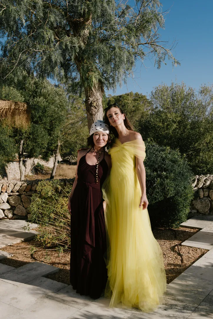 Rachel in haar gele bruidsjurk op Menorca samen met goede vriendin Alina Cho.