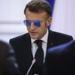 Macron draagt zonnebril.