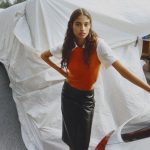 Malika El Maslouhi in een oranje top in Amsterdam