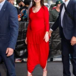 Anne Hathaway draagt een rode zwangerschapslook van Ashlyn tijdens een verschijning in New York.