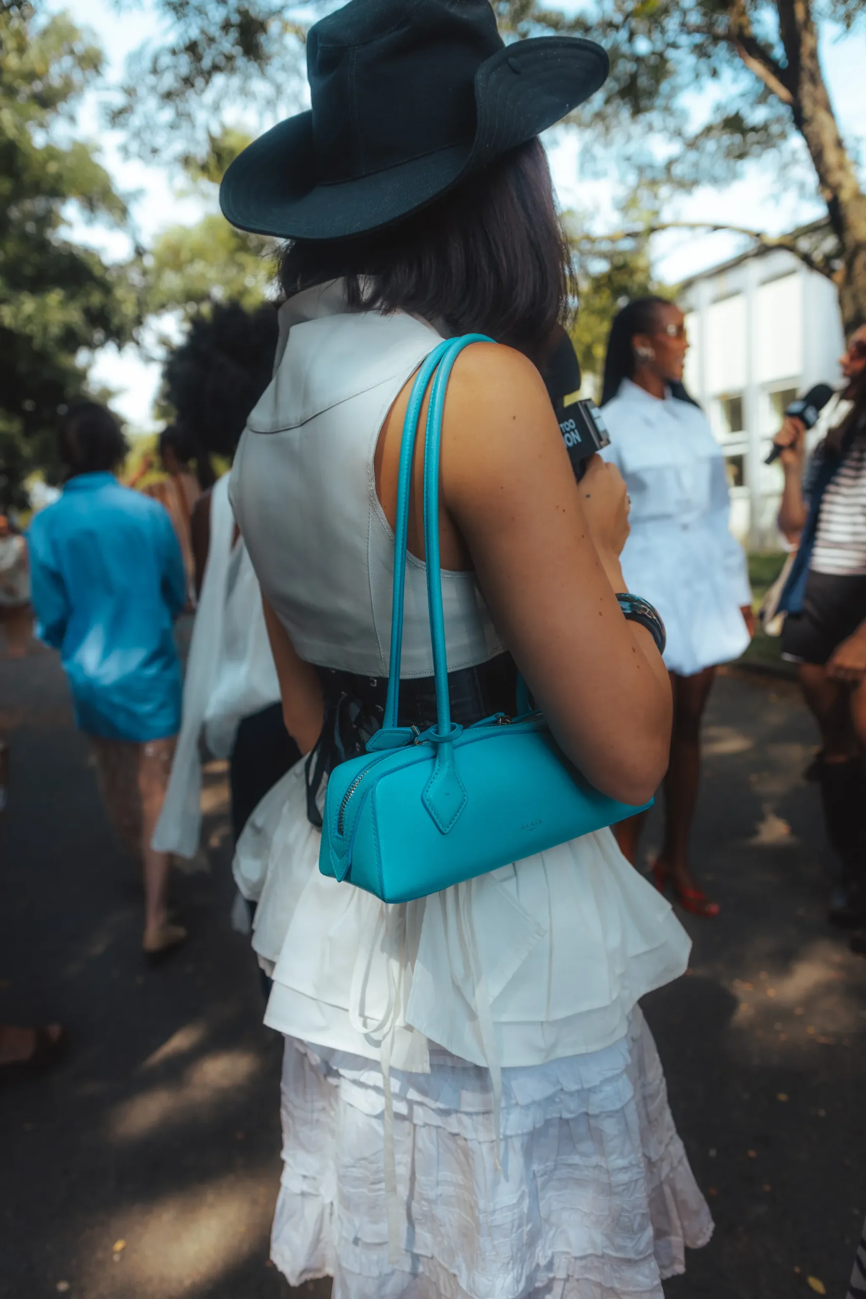 Een streetstyler in Kopenhagen draagt een gekleurde tas