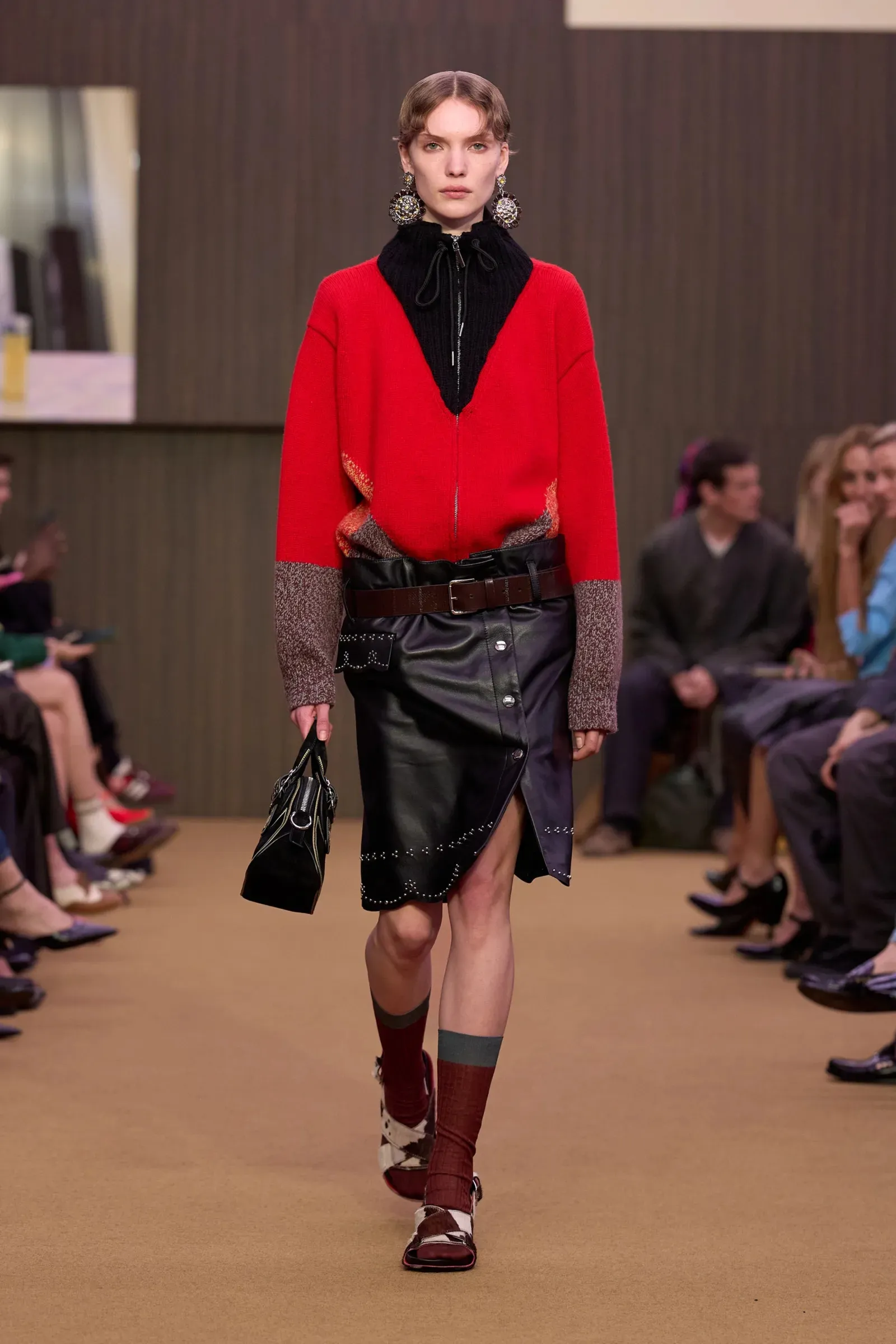 Een model draagt een leren rok op de catwalk van Marni