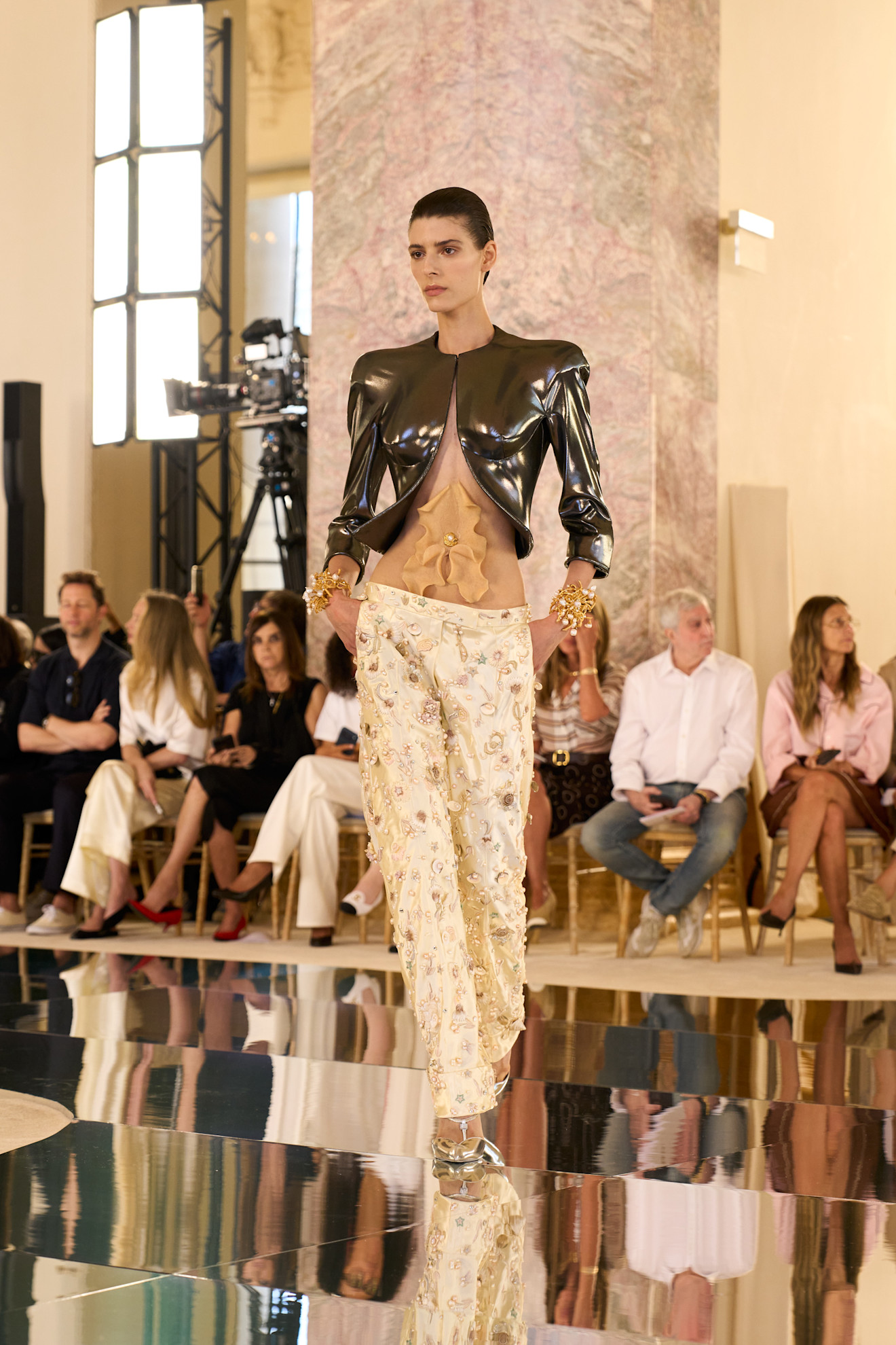 Een model draagt een navelpiercing op de catwalk van Schiaparelli